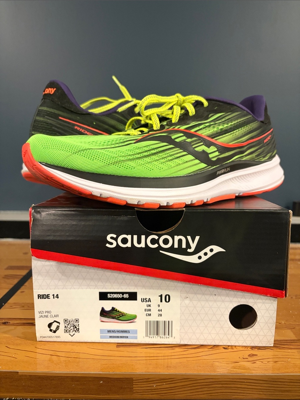 Saucony men's running shoes in bright green with black and orange accents